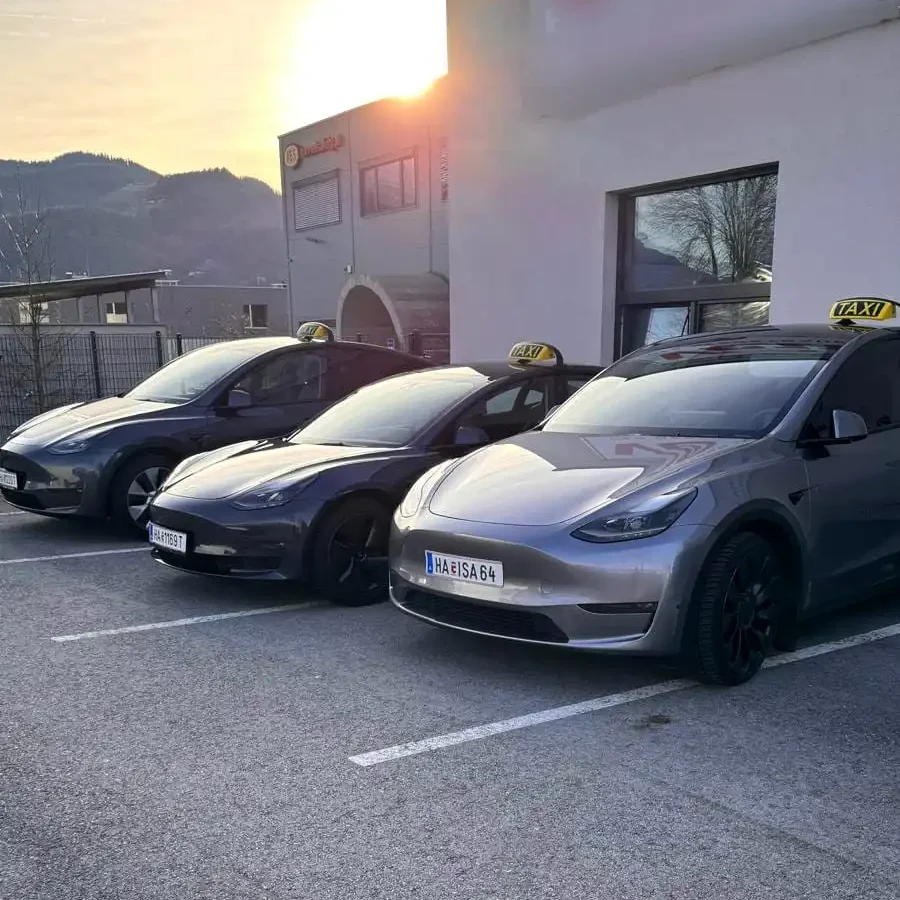 Drei Tesla Taxis von Taxi Hallein vor dem Firmengebäude bei Sonnenuntergang
